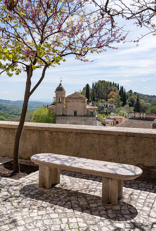 Chiesa della Santissima Annunziata站在公园的石凳后面，意大利的Casperia Lazio